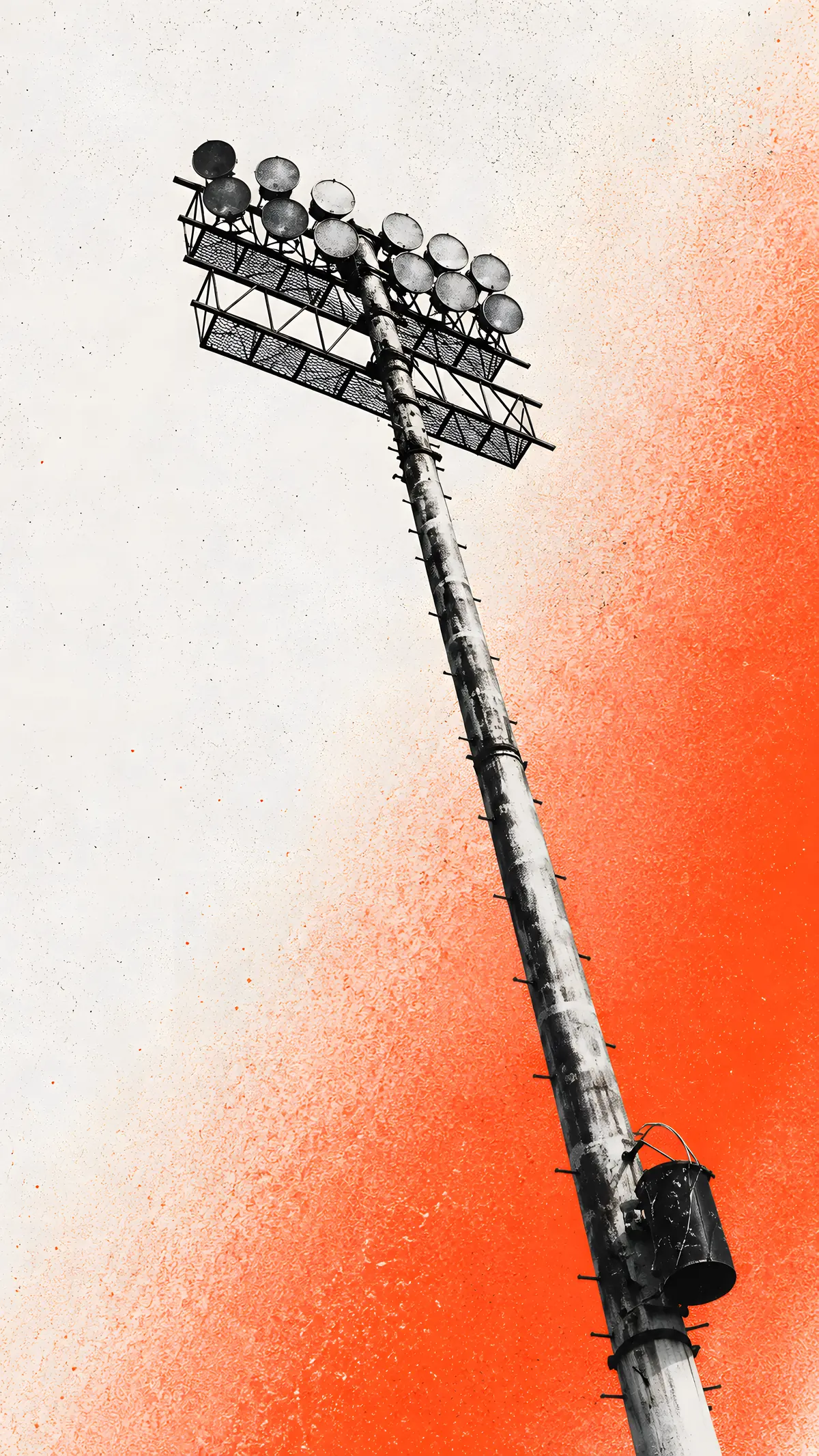 A floodlight pylon against an orange sky